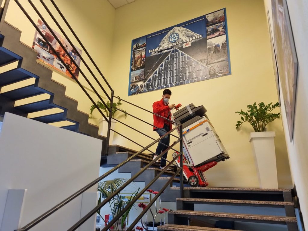 Un hombre transporta una fotocopiadora por las escaleras con el sube escaleras eléctrico Buddy Lift